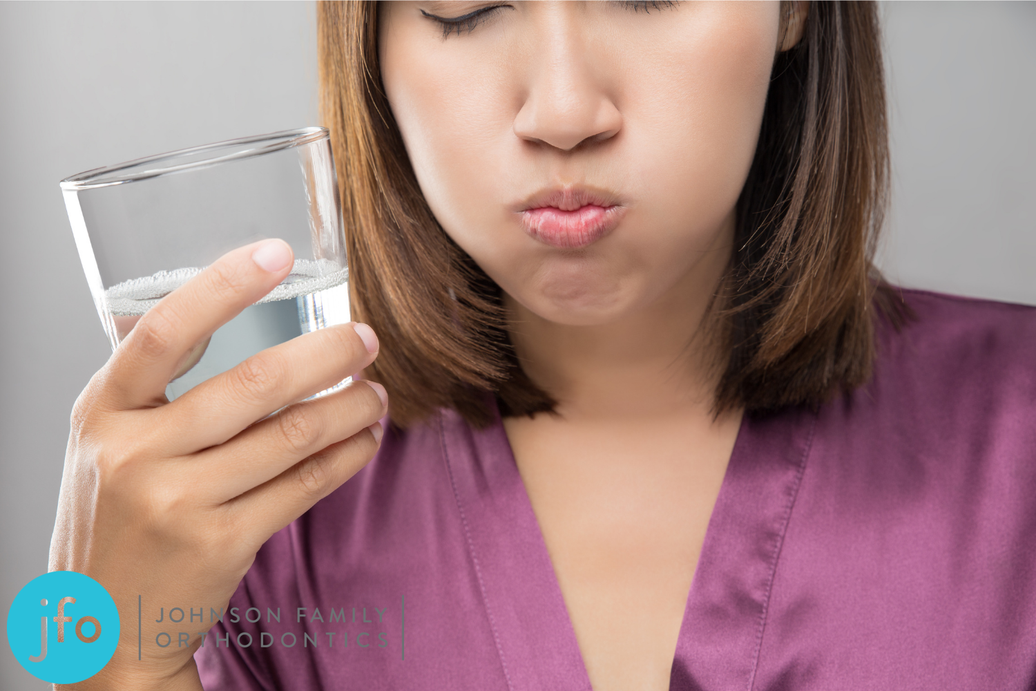 Woman swishing water in her mouth between her braces